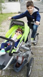 Bambino in bicicletta collegata a passeggino con bambina